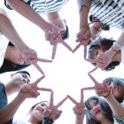 group of people forming star using their hands